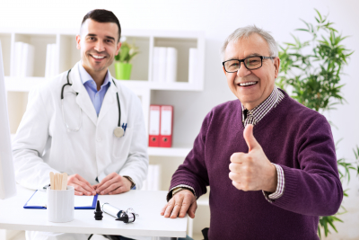 satisfied senior man with young doctor in office
